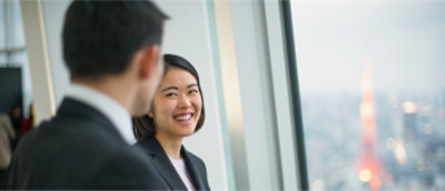 Two persons are smiling and talking.