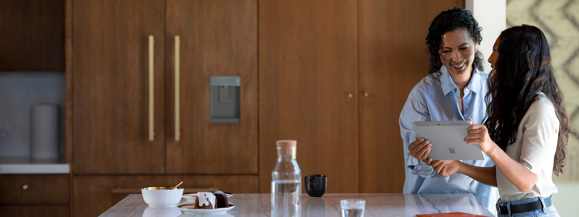 An adult and a child using Surface Go 3 in the kitchen.