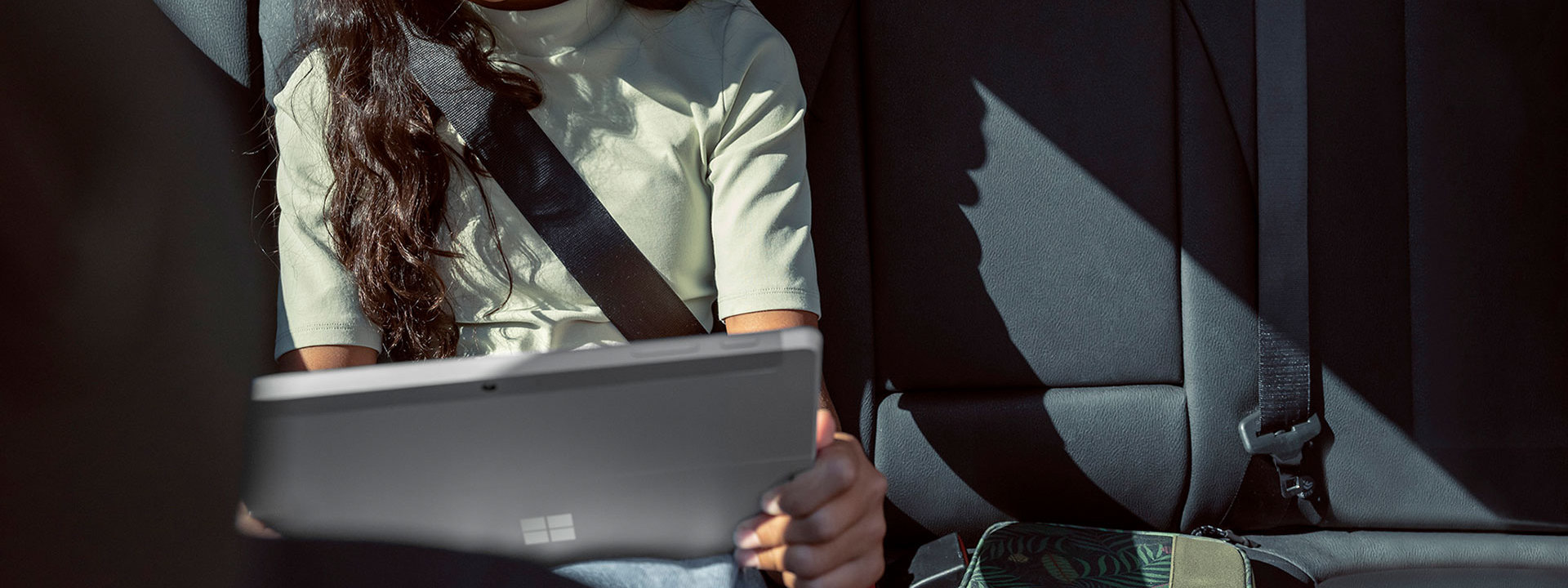 A child using a Surface Go 3 in the car.