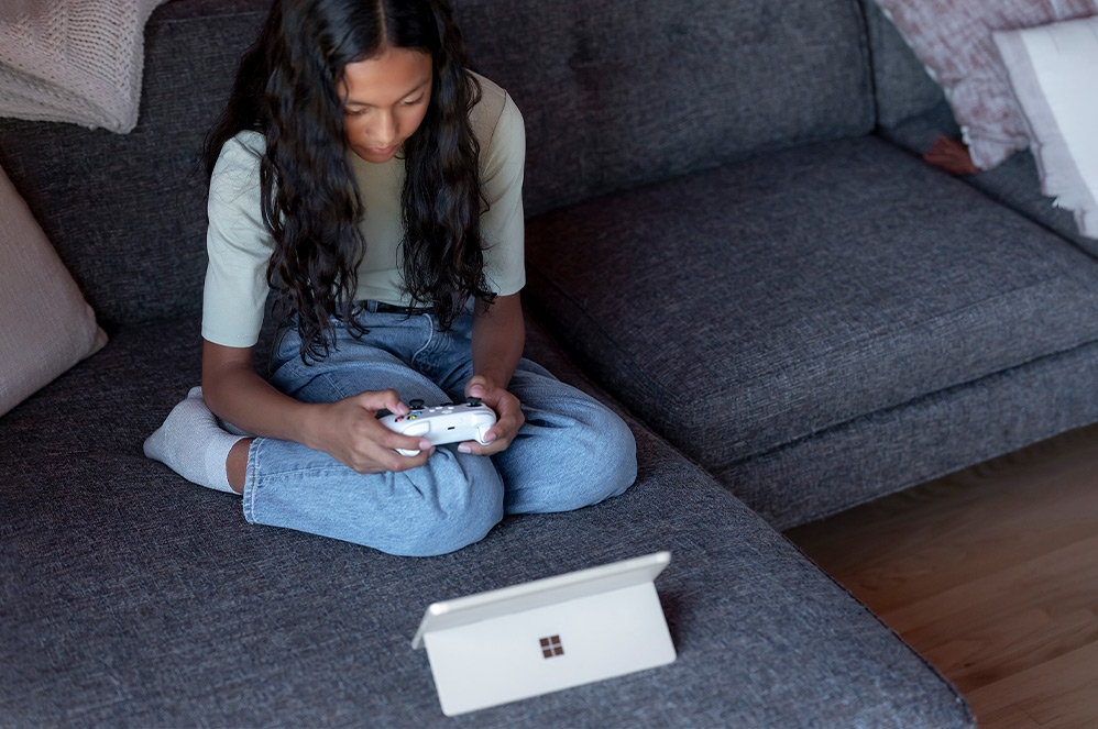 Dziecko grające na komputerze Surface Go 3 wspartym na podpórce