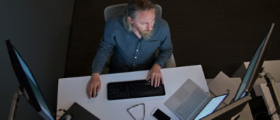 A man sitting at a desk using a computer.