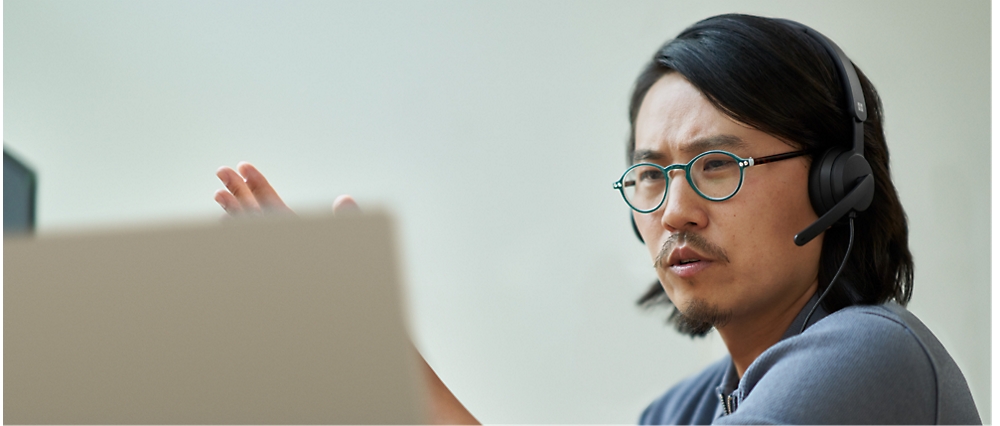 Une personne portant des lunettes et regardant un ordinateur