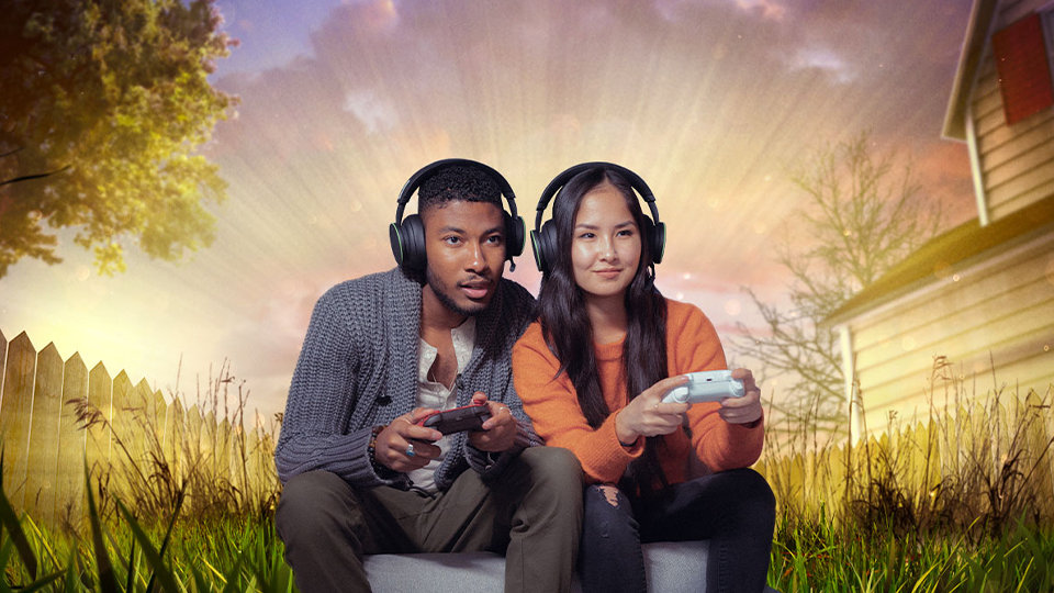 Twee mensen spelen op een Xbox in de tuin van Grounded