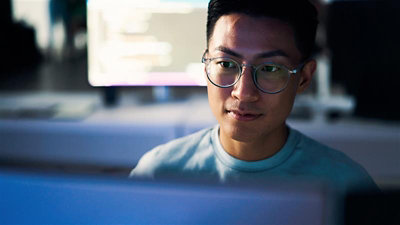 A person sitting at a desk using a computer
