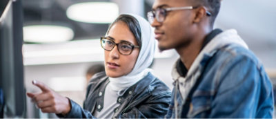 A person and another person looking at computer screen