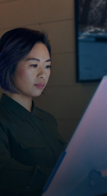 A woman looking at a monitor.