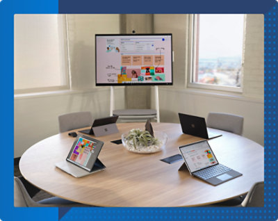 A table with laptops and a tablet on it.