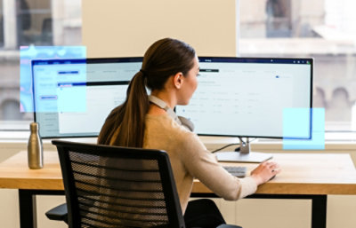 A woman sitting in front of a computer on a chair