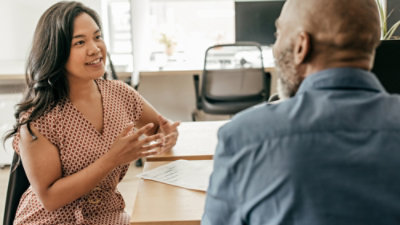 A person and another person talking at a table