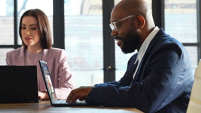 A Man and women looking at laptop and working
