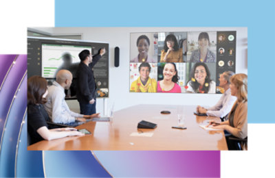 A group of professionals in a conference room engaging in a video call with diverse colleagues displayed on a large screen.