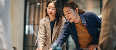 A group of women looking at a windmill model