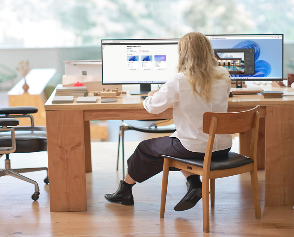 Una persona seduta alla scrivania che guarda un computer