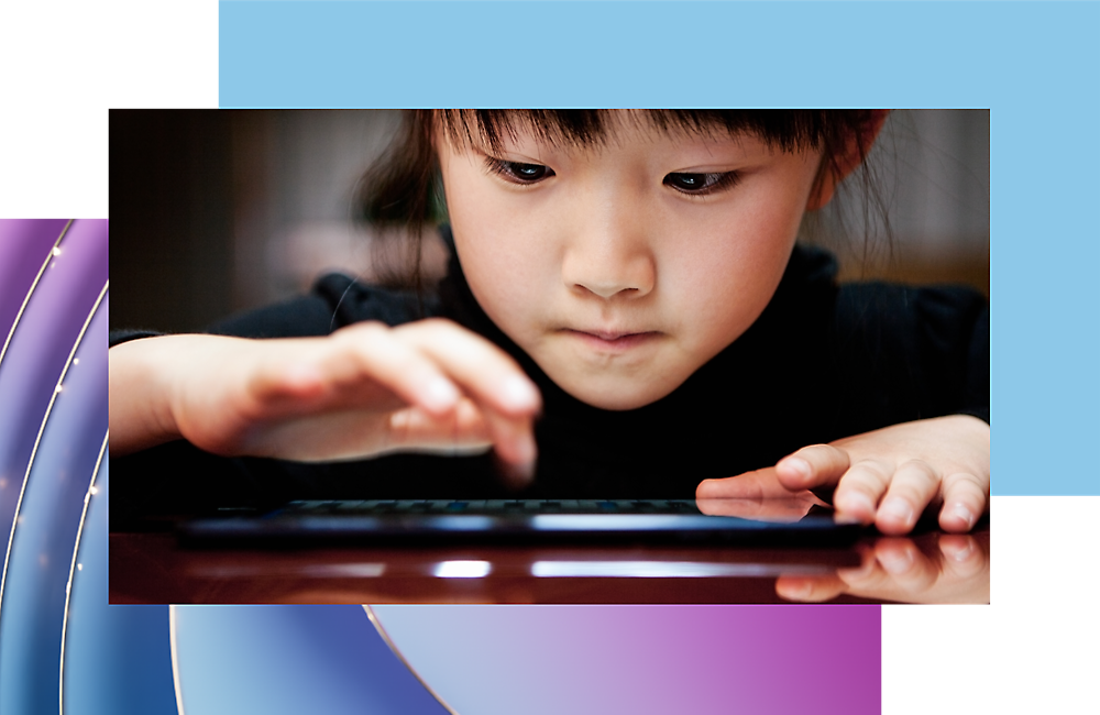 A child focusing intently on using a digital tablet.