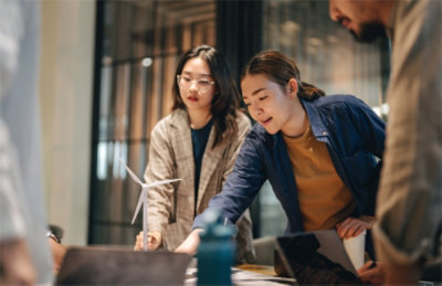 A group of people looking at a windmill.