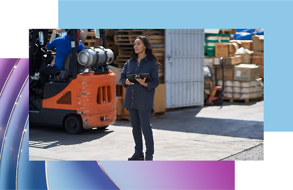 Mujer que sostiene un portapapeles en un emplazamiento industrial con un montacargas en segundo plano.