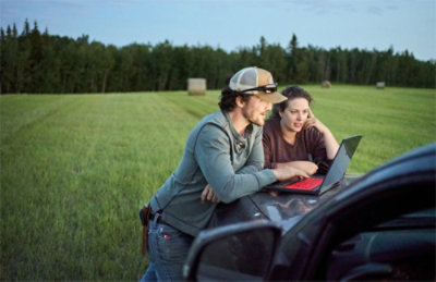 A man and woman looking at a laptop.