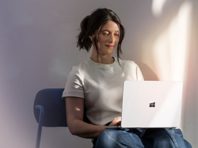 A person sitting on a chair using a laptop.
