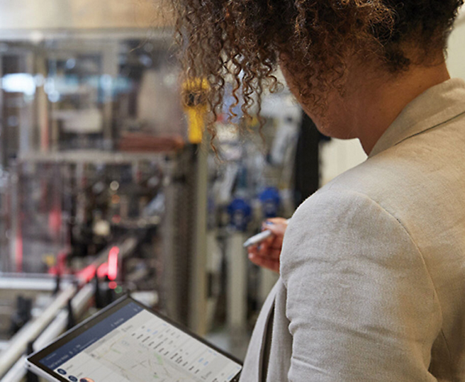 Mulher monitorando processos industriais em um tablet digital.
