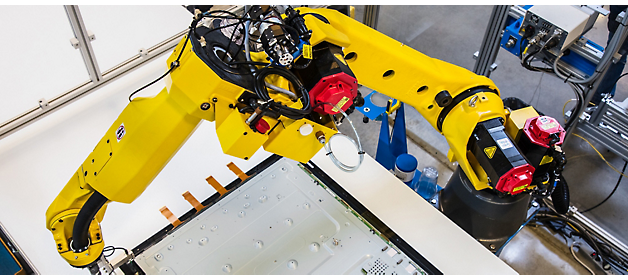 Braço de robô industrial executando trabalho de precisão em uma linha de produção.