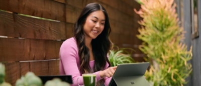 Osoba sedi napolju i koristi računar