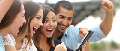 Grupa ljudi koja se smeje i gleda u tablet