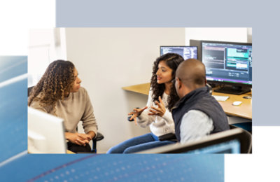 Two women's and one man discussing something in computer room. 
