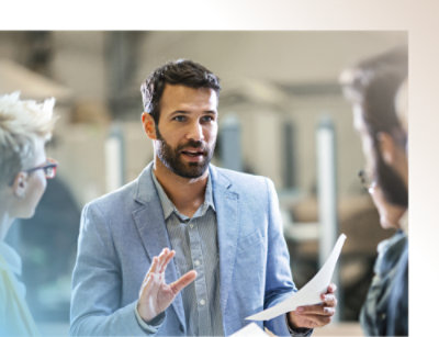A man discussing document with colleagues during a team meeting.
