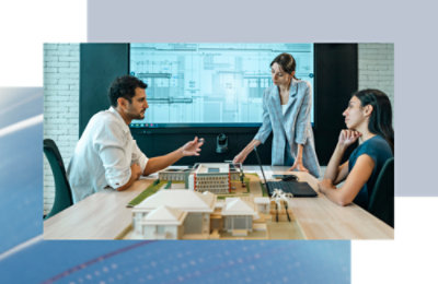 A group of people sitting around a table with a model of a building.