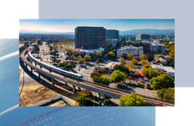 A train on a bridge in a city.