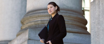 A person holding a tablet and looking to the side.