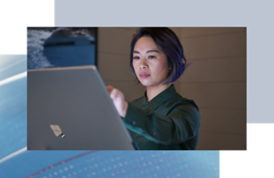 A person wearing a green shirt using a laptop.