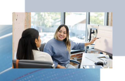 Two women looking at a desktop.