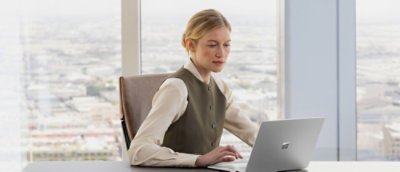 A person sitting at a desk using a laptop.