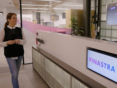A person walking in a lobby with a Finestra sign