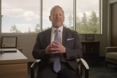 A man in a suit and tie sitting in a chair
