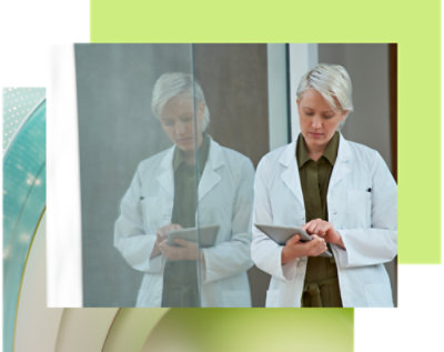 A person in a white coat using a tablet.