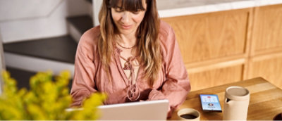 Masaya oturmuş, dizüstü bilgisayar kullanan bir kadın.