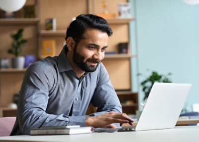 A man sitting at a desk using a laptop.