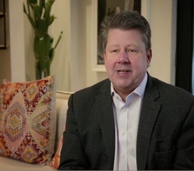 Un homme en costume aux cheveux hérissés.