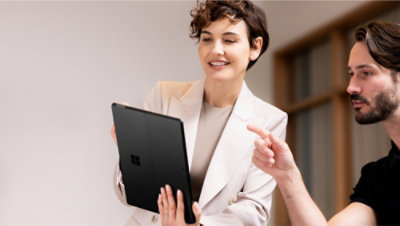 Image 8: A woman holding a tablet and pointing at something.