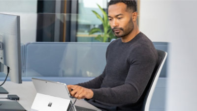 Image 9: A man sitting on a chair using a laptop.