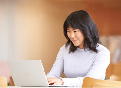 A person using a laptop at a kitchen counter