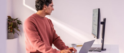 Чоловік сидить за столом, працюючи на ноутбуці.