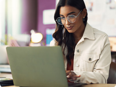 A woman wearing glasses and a white jacket.