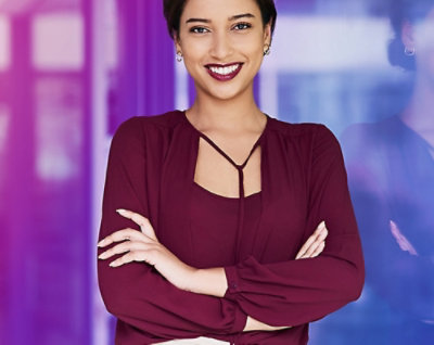 Confident woman smiling with arms crossed against a colorful background