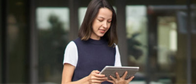 A woman with brown hair holding a tablet.