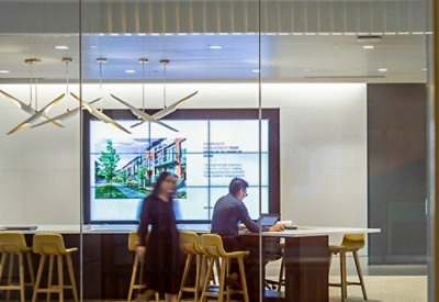 A man and woman standing in front of a computer