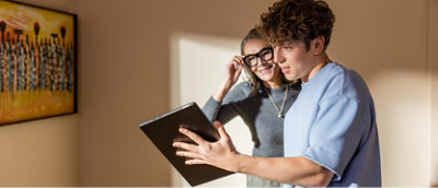 A man and woman holding a tablet.