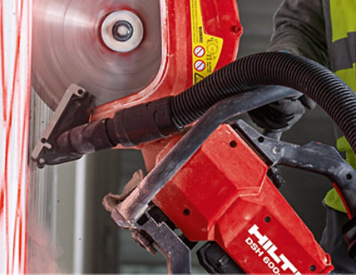 A close-up of a red and black circular saw with the text HILT DSH 600.